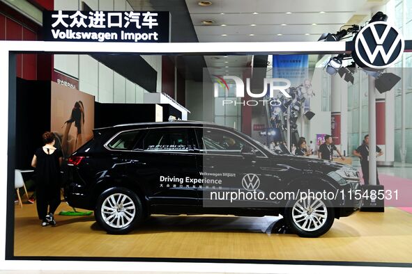 People look at various vehicles at the 23rd Autumn International Auto Show in Qingdao, China, on September 5, 2024. 