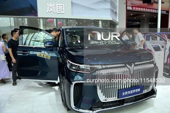 People look at various vehicles at the 23rd Autumn International Auto Show in Qingdao, China, on September 5, 2024. 