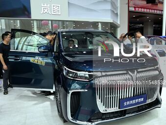 People look at various vehicles at the 23rd Autumn International Auto Show in Qingdao, China, on September 5, 2024. (