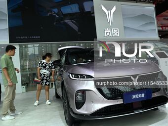 People look at various vehicles at the 23rd Autumn International Auto Show in Qingdao, China, on September 5, 2024. (