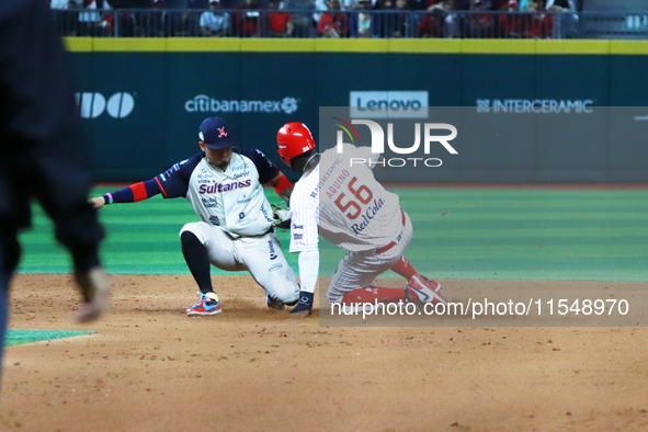 Aristides Aquino #56 of Diablos Rojos slides to avoid the tag by second baseman Ramiro Pena #19 of Sultanes de Monterrey during the match 1...