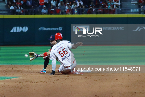 Aristides Aquino #56 of Diablos Rojos slides to avoid the tag by second baseman Ramiro Pena #19 of Sultanes de Monterrey during the match 1...