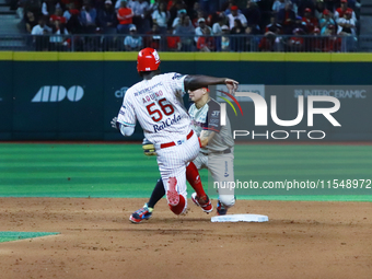 Aristides Aquino #56 of Diablos Rojos slides to avoid the tag by second baseman Ramiro Pena #19 of Sultanes de Monterrey during the match 1...