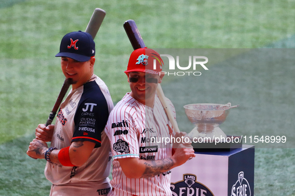 Ramiro Pena #1 of Sultanes de Monterrey and Juan Carlos Gamboa #47 of Diablos Rojos pose with the Zaachila trophy before match 1 of the Mexi...