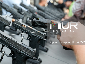 Visitors look at guns from UM as they attend the 32nd International Defence Industry Exhibition - MSPO i Targi Kielce in central Poland on S...