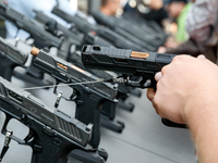 Visitors look at guns from UM as they attend the 32nd International Defence Industry Exhibition - MSPO i Targi Kielce in central Poland on S...