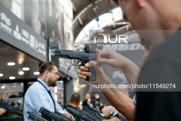 Visitors look at guns from UM as they attend the 32nd International Defence Industry Exhibition - MSPO i Targi Kielce in central Poland on S...