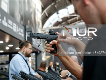 Visitors look at guns from UM as they attend the 32nd International Defence Industry Exhibition - MSPO i Targi Kielce in central Poland on S...