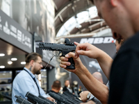 Visitors look at guns from UM as they attend the 32nd International Defence Industry Exhibition - MSPO i Targi Kielce in central Poland on S...