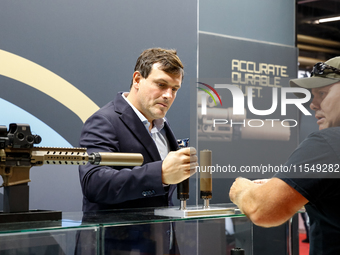 Visitors look at guns from Acheron Corp as they attend the 32nd International Defence Industry Exhibition - MSPO i Targi Kielce in central P...