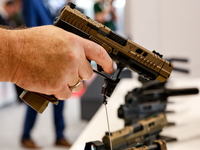 Visitors look at guns from Beretta Defence Technologies as they attend the 32nd International Defence Industry Exhibition - MSPO i Targi Kie...