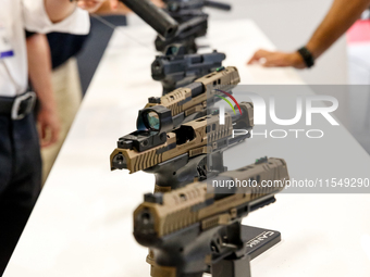 Visitors look at guns from Beretta Defence Technologies as they attend the 32nd International Defence Industry Exhibition - MSPO i Targi Kie...