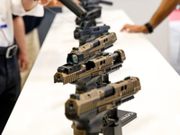 Visitors look at guns from Beretta Defence Technologies as they attend the 32nd International Defence Industry Exhibition - MSPO i Targi Kie...