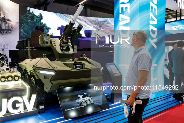 Visitors look at a model of UGV armoured vehicle from Hyundai as they attend the 32nd International Defence Industry Exhibition - MSPO i Tar...