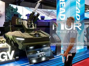 Visitors look at a model of UGV armoured vehicle from Hyundai as they attend the 32nd International Defence Industry Exhibition - MSPO i Tar...