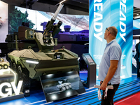 Visitors look at a model of UGV armoured vehicle from Hyundai as they attend the 32nd International Defence Industry Exhibition - MSPO i Tar...