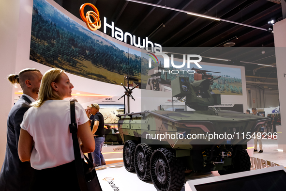 Visitors look at a model of Arion-Smet armoured vehicle from Hanwha as they attend the 32nd International Defence Industry Exhibition - MSPO...