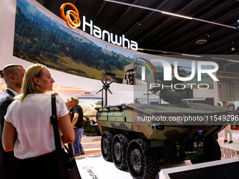 Visitors look at a model of Arion-Smet armoured vehicle from Hanwha as they attend the 32nd International Defence Industry Exhibition - MSPO...