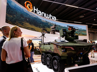 Visitors look at a model of Arion-Smet armoured vehicle from Hanwha as they attend the 32nd International Defence Industry Exhibition - MSPO...