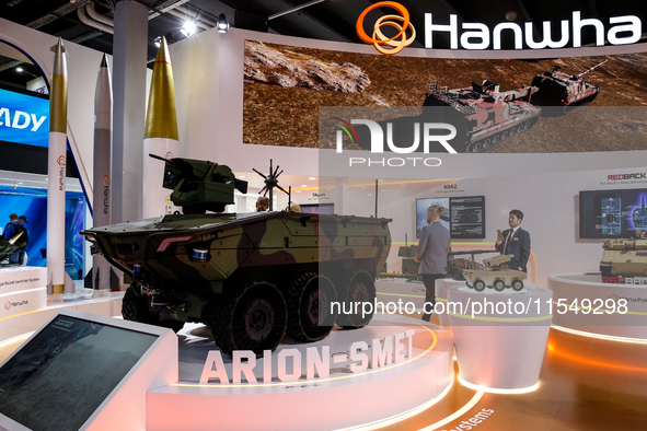 Visitors look at a model of Arion-Smet armoured vehicle from Hanwha as they attend the 32nd International Defence Industry Exhibition - MSPO...