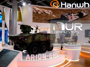 Visitors look at a model of Arion-Smet armoured vehicle from Hanwha as they attend the 32nd International Defence Industry Exhibition - MSPO...