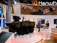 Visitors look at a model of Arion-Smet armoured vehicle from Hanwha as they attend the 32nd International Defence Industry Exhibition - MSPO...