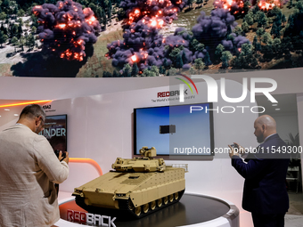 Visitors look at a model of Red Back tank from Hanwha as they attend the 32nd International Defence Industry Exhibition - MSPO i Targi Kielc...