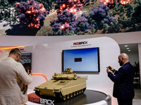 Visitors look at a model of Red Back tank from Hanwha as they attend the 32nd International Defence Industry Exhibition - MSPO i Targi Kielc...