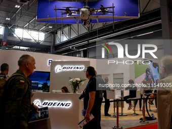 Visitors look at drones from Boeing as they attend the 32nd International Defence Industry Exhibition - MSPO i Targi Kielce in central Polan...