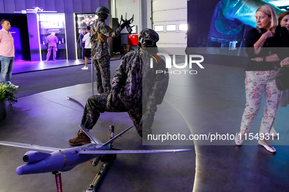 Visitor look at mannequin with a drone from WB Group as they attends the 32nd International Defence Industry Exhibition - MSPO i Targi Kielc...