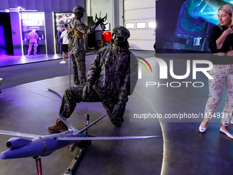 Visitor look at mannequin with a drone from WB Group as they attends the 32nd International Defence Industry Exhibition - MSPO i Targi Kielc...