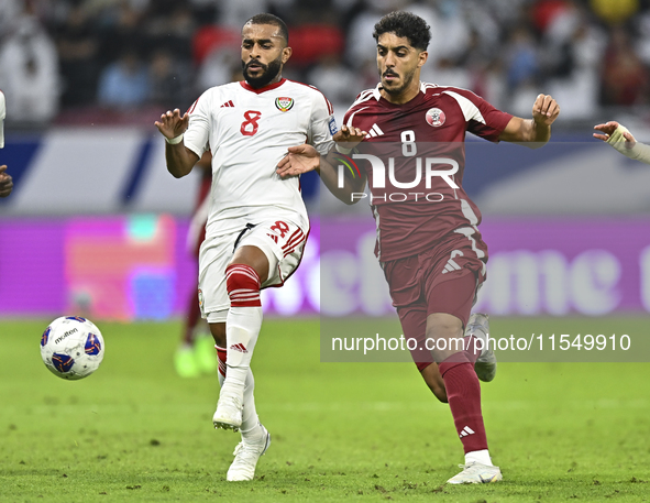 Jassem Gaber of Qatar battles for the ball with Tahnoon Hamdan of the United Arab Emirates during the qualification 3rd round for the FIFA W...