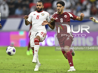 Jassem Gaber of Qatar battles for the ball with Tahnoon Hamdan of the United Arab Emirates during the qualification 3rd round for the FIFA W...