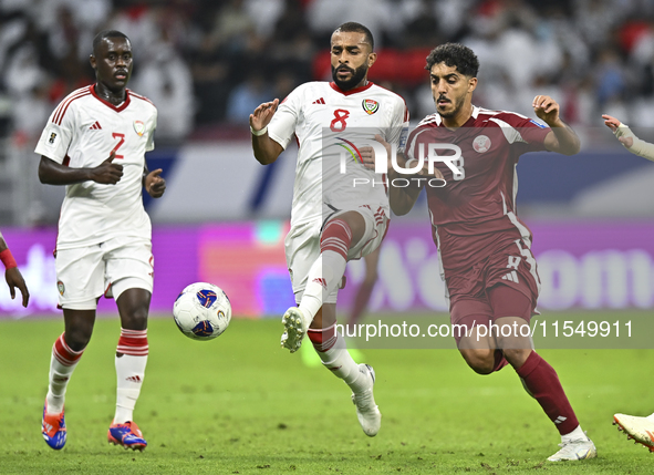 Jassem Gaber of Qatar battles for the ball with Tahnoon Hamdan of the United Arab Emirates during the qualification 3rd round for the FIFA W...