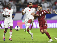 Jassem Gaber of Qatar battles for the ball with Tahnoon Hamdan of the United Arab Emirates during the qualification 3rd round for the FIFA W...