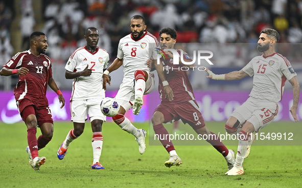 Jassem Gaber (#8) of Qatar battles for the ball with Tahnoon Hamdan (#8) of the United Arab Emirates during the qualification 3rd round for...