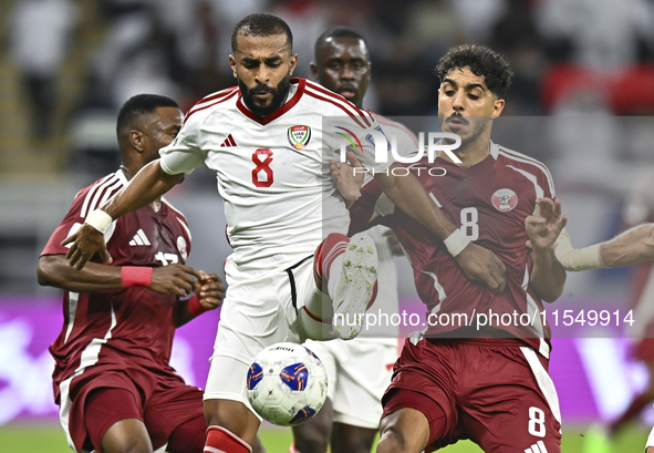 Jassem Gaber (#8) of Qatar battles for the ball with Tahnoon Hamdan (#8) of the United Arab Emirates during the qualification 3rd round for...