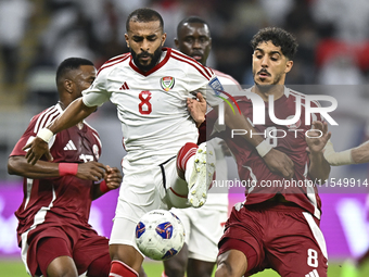 Jassem Gaber (#8) of Qatar battles for the ball with Tahnoon Hamdan (#8) of the United Arab Emirates during the qualification 3rd round for...