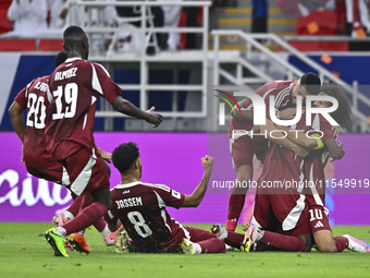 Ibrahim Mohammadali (second from right) of Qatar celebrates with his teammate after scoring during the qualification third round for the FIF...