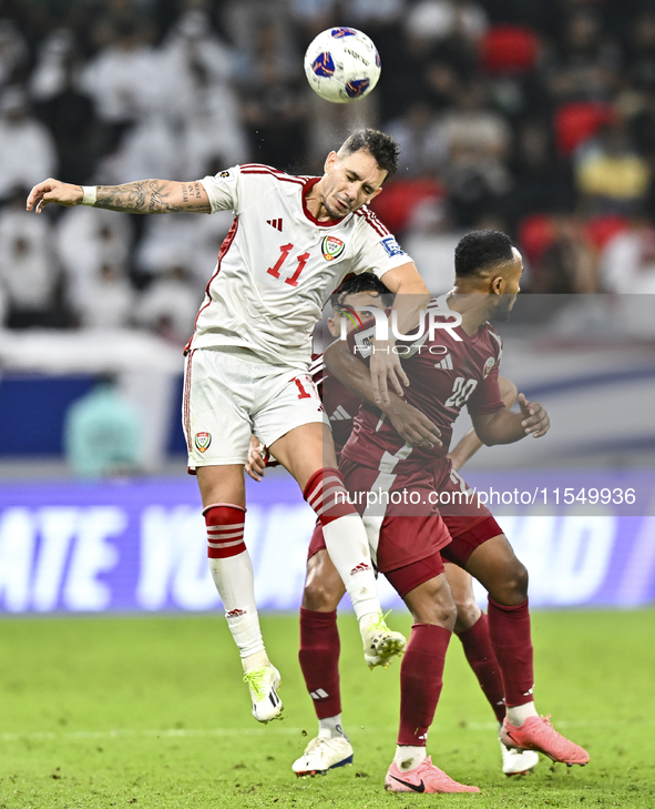 Ahmed Fathy (R) of Qatar battles for the ball with Caio Correa (L) of the United Arab Emirates during the qualification 3rd round for the FI...