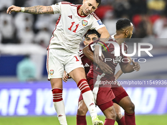 Ahmed Fathy (R) of Qatar battles for the ball with Caio Correa (L) of the United Arab Emirates during the qualification 3rd round for the FI...