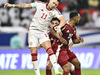 Ahmed Fathy (R) of Qatar battles for the ball with Caio Correa (L) of the United Arab Emirates during the qualification 3rd round for the FI...