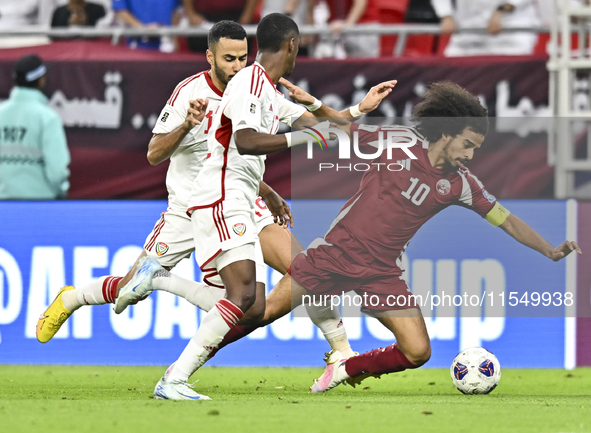 Akram Afif (R) of Qatar battles for the ball with Khaled Aldhanhani (L) of the United Arab Emirates during the qualification 3rd round for t...