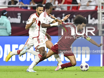 Akram Afif (R) of Qatar battles for the ball with Khaled Aldhanhani (L) of the United Arab Emirates during the qualification 3rd round for t...