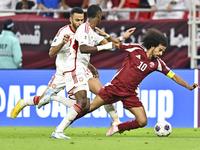 Akram Afif (R) of Qatar battles for the ball with Khaled Aldhanhani (L) of the United Arab Emirates during the qualification 3rd round for t...