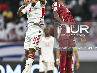 Ibrahim Mohammadali of Qatar battles for the ball with Tahnoon Hamdan of the United Arab Emirates during the qualification 3rd round for the...