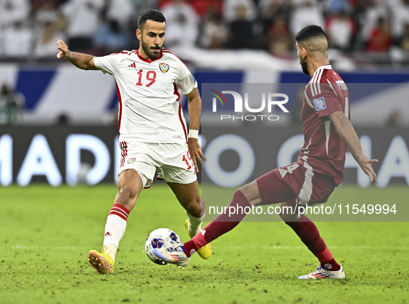 Mohammed Waad of Qatar battles for the ball with Khaled Aldhanhani of the United Arab Emirates during the qualification 3rd round for the FI...