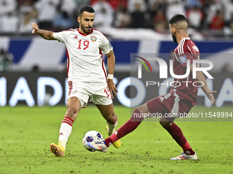 Mohammed Waad of Qatar battles for the ball with Khaled Aldhanhani of the United Arab Emirates during the qualification 3rd round for the FI...