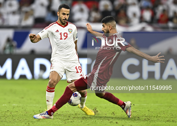 Mohammed Waad of Qatar battles for the ball with Khaled Aldhanhani of the United Arab Emirates during the qualification 3rd round for the FI...