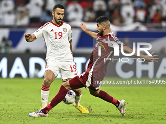 Mohammed Waad of Qatar battles for the ball with Khaled Aldhanhani of the United Arab Emirates during the qualification 3rd round for the FI...